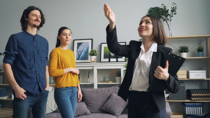 A real estate agent showing a modern home to prospective buyers