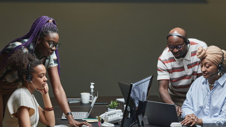 An IT support team helping employees from a modern service desk
